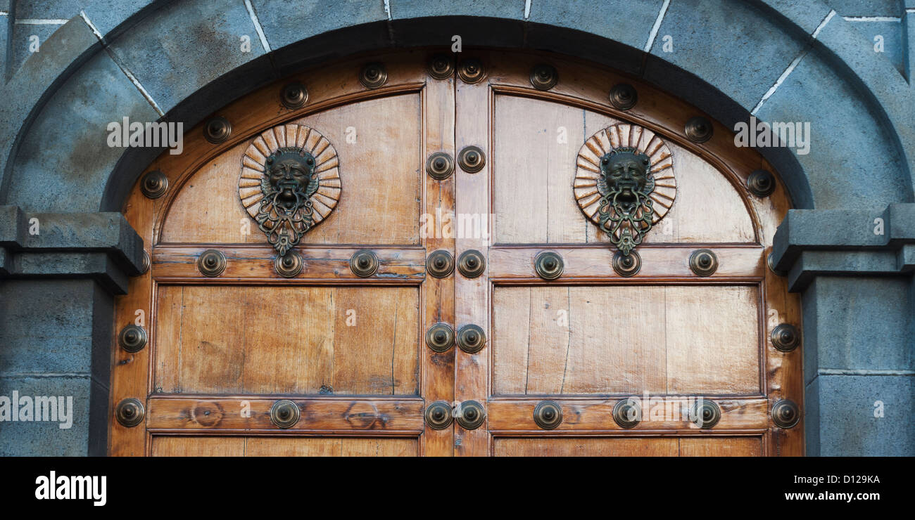 A Human Face As A Door Knocker And Decorative Rivets On A Wooden