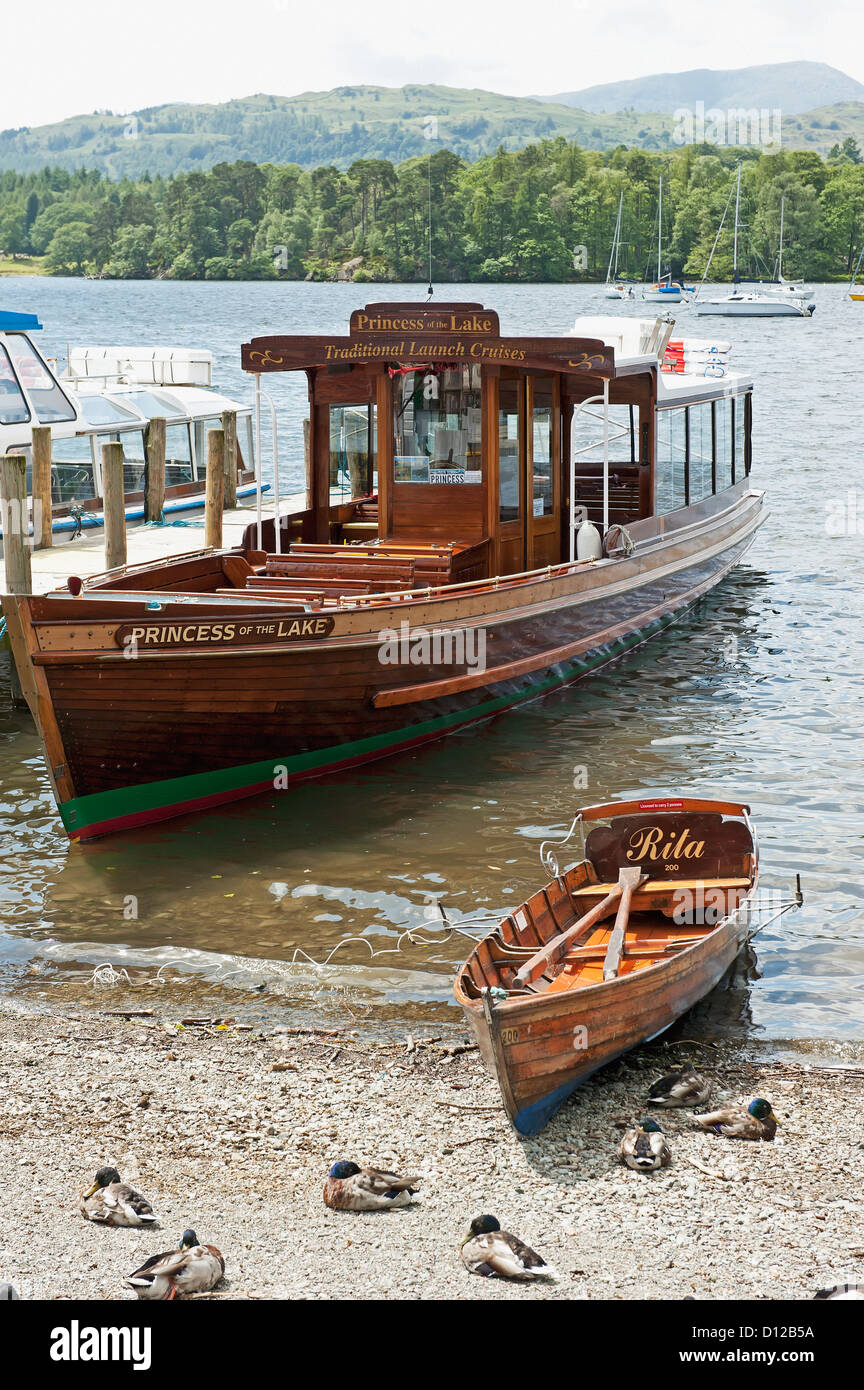 A Large And Small Wooden Boat Beside Each Other In The Shallow Water Along The Beach; England Stock Photo