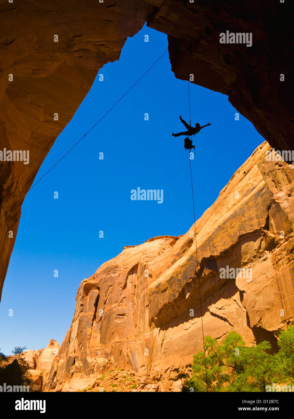 A Female Athlete Rappeling Down A Dry Utah Slot Canyon Waterfall; Hanksville Utah United States Of America Stock Photo