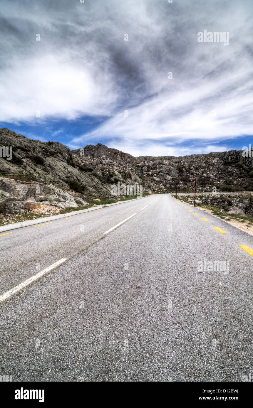 Asphalt road in the mountains and blue sky with clouds Stock Photo - Alamy