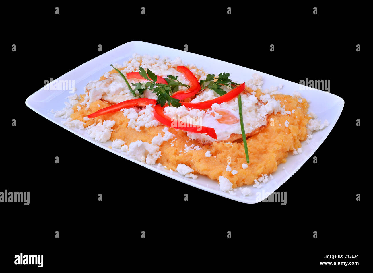 Polenta with cheese and fried eggs, romanian cuisine. Isolated with clipping mask. Stock Photo