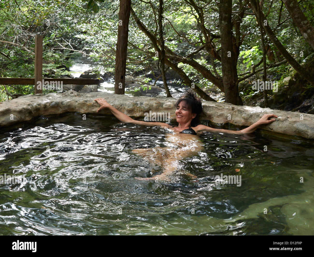 woman relaxing in an outdoor spa; hot springs; thermal spring; Las Pailas; Ricòn de la Vieja National Park; Costa Rica Stock Photo