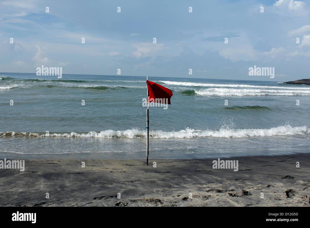 A red flag at Kovalam beach warning tourists of rough sea conditions Stock Photo