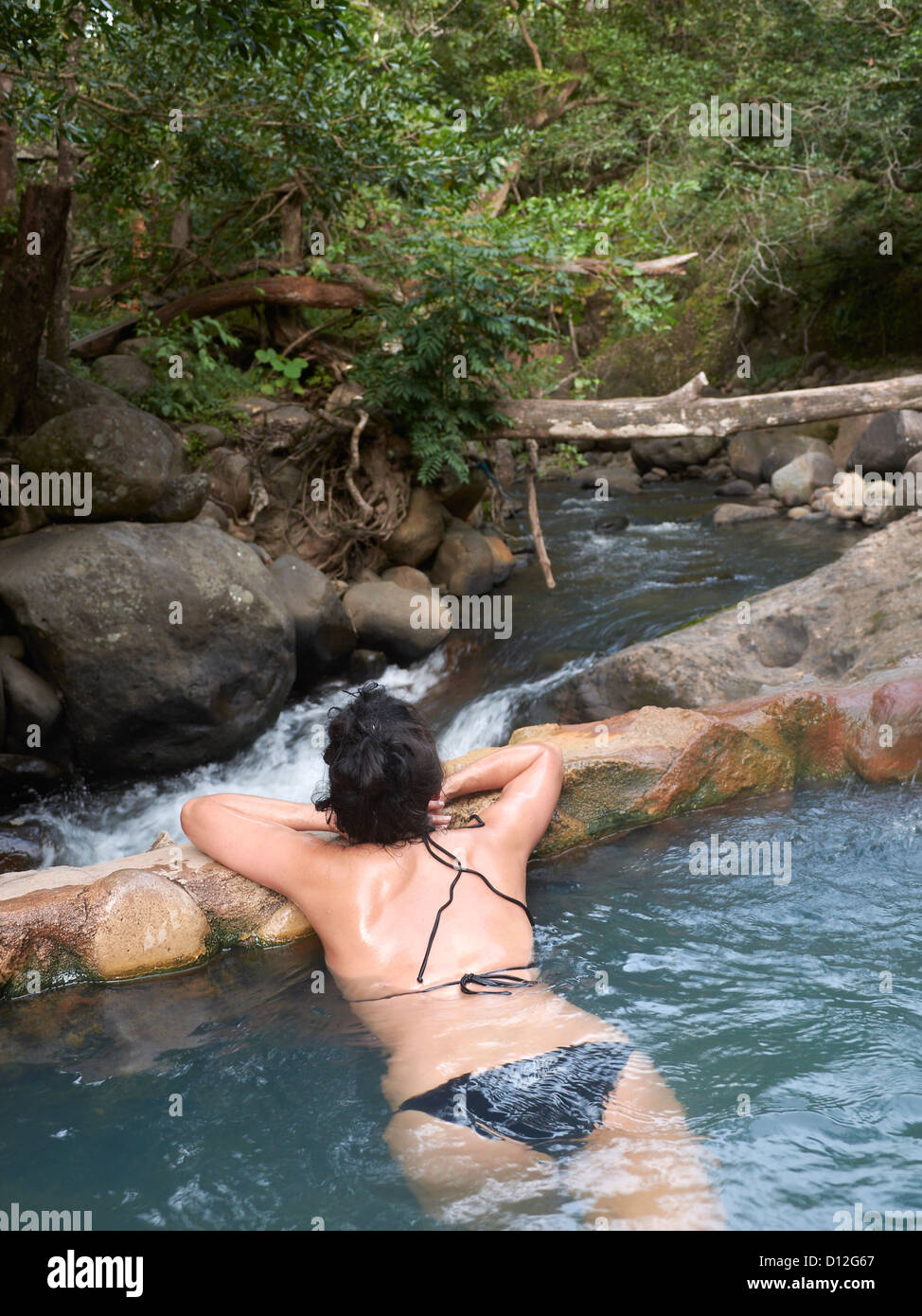 woman relaxing in an outdoor spa; hot springs; thermal spring; Las Pailas; Ricòn de la Vieja National Park; Costa Rica Stock Photo