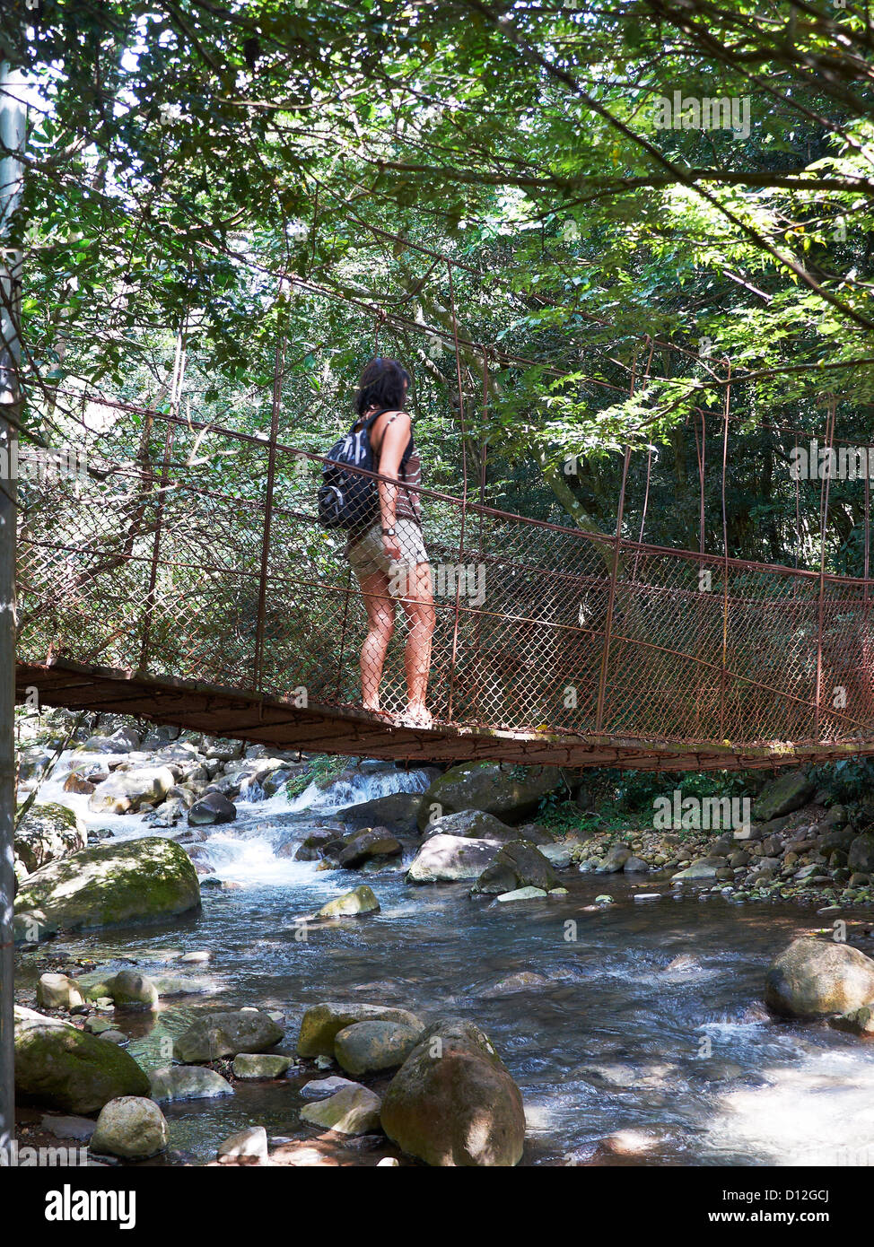 woman passsing a suspension bridge; Las Pailas; Ricòn de la Vieja National Park;Costa Rica Stock Photo