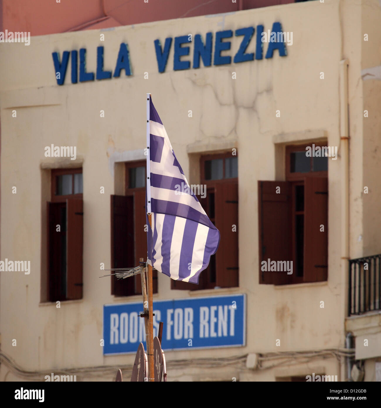 A Greek flag flies at the Venetian Harbour of Chania on Crete, Greece. Stock Photo