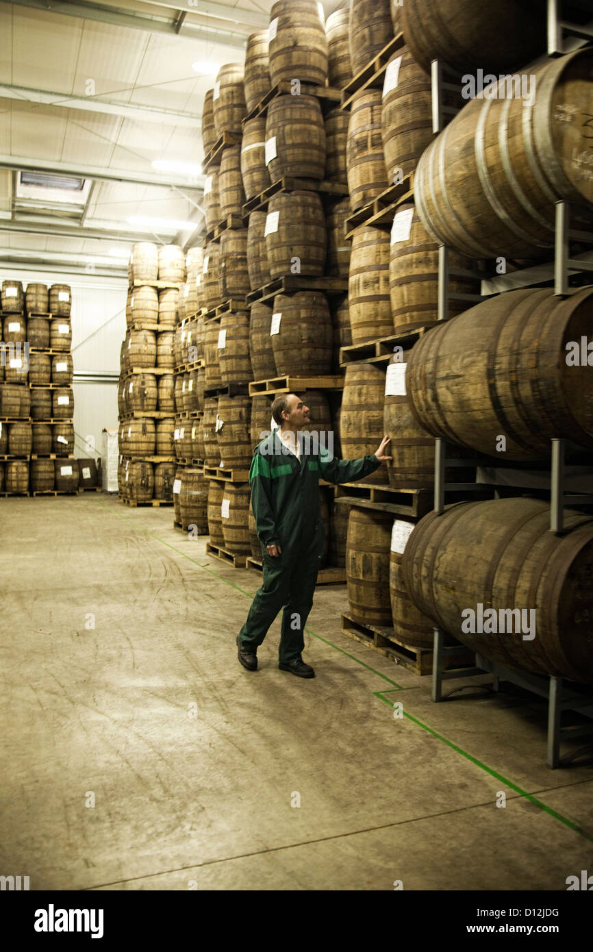 A worker counts whisky casks in the warehouse at the Warengham distillery in Lannion, France