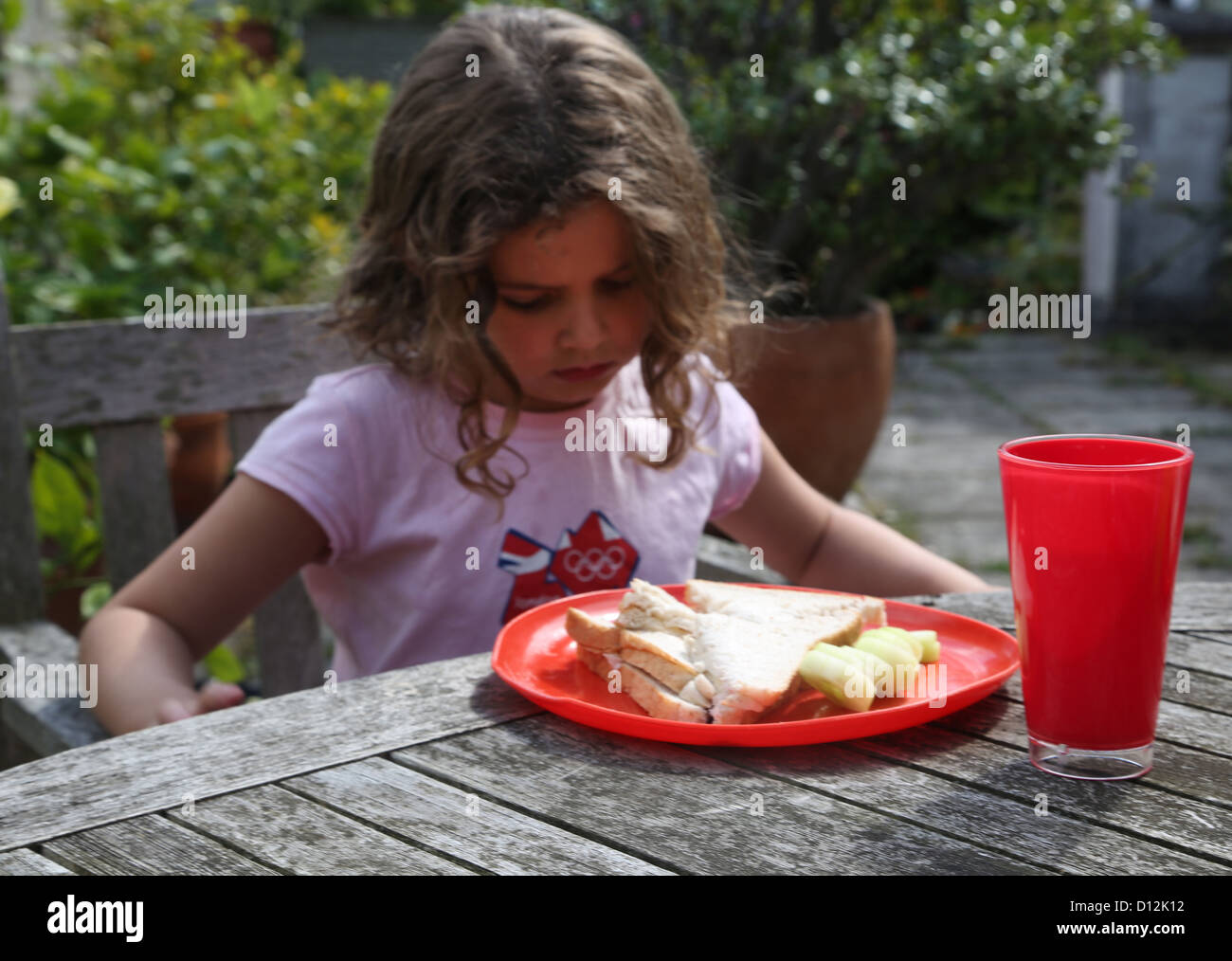 6 Year Old Girl Looking Down Refusing To Eat Her Lunch Surrey England Stock Photo