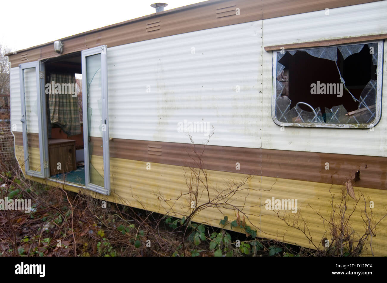 derelict mobile home homes trashed smashed window windows vandalized holiday from hell bad accommodation hotel hotels rooms site Stock Photo