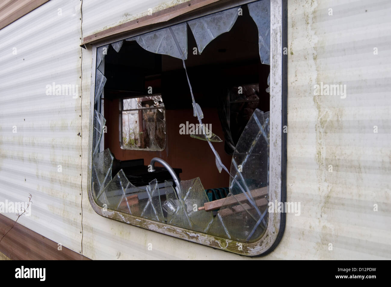 derelict mobile home homes trashed smashed window windows vandalized holiday from hell bad accommodation hotel hotels rooms site Stock Photo