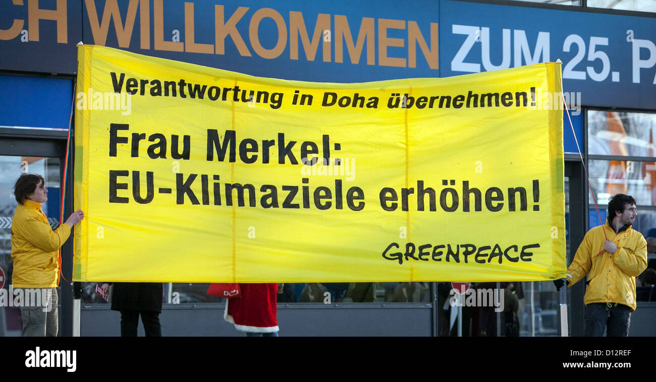 HANDOUT - Greenpeace-Aktivisten stehen am 04.12.2012 vor dem Eingang zum Konferenzgebäude des 25. Bundesparteitages der CDU in Hannover (Niedersachsen) mit einem Transparent. Mit der Losung "Verantwortung in Doha übernehmen! Frau Merkel: EU-Klimaziele erhöhen!" fordern sie von der Kanzlerin mehr Einsatz für den Klimaschutz. Foto: Franz Bischof / Greenpeace (Verwdenung nur im Zusammenhang mit der Berichterstattung bei Urhebernennung, keine Archivierung) Stock Photo