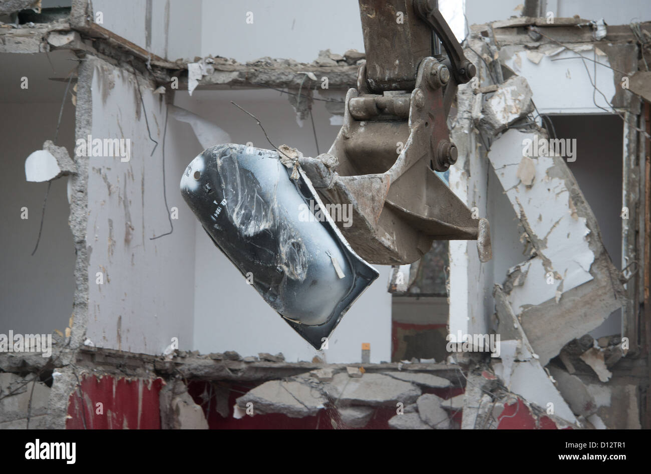 A crane tears down an apartment building from the GDR times in the residential area Knieper West in Stralsund, Germany, 04 December 2012. The Stralsund housing association SWG is tearing down its plattenbau buildings in the area as part of the program 'Stadtumbau Ost' (City redevelopment east). Photo: Stefan Sauer Stock Photo