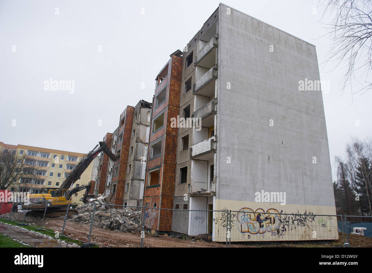 A crane tears down an apartment building from the GDR times in the residential area Knieper West in Stralsund, Germany, 04 December 2012. The Stralsund housing association SWG is tearing down its plattenbau buildings in the area as part of the program 'Stadtumbau Ost' (City redevelopment east). Photo: Stefan Sauer Stock Photo