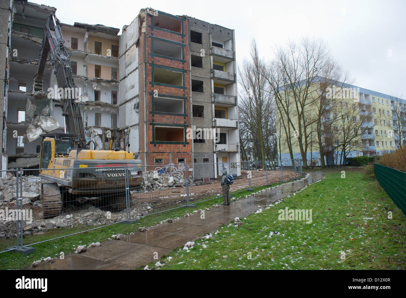 A crane tears down an apartment building from the GDR times in the residential area Knieper West in Stralsund, Germany, 04 December 2012. The Stralsund housing association SWG is tearing down its plattenbau buildings in the area as part of the program 'Stadtumbau Ost' (City redevelopment east). Photo: Stefan Sauer Stock Photo