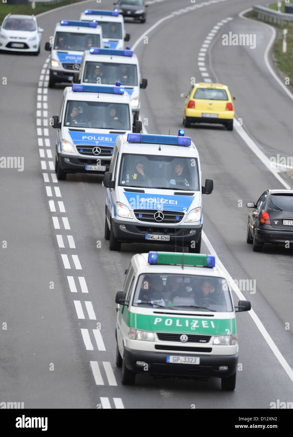 Police vehicles drive in front of a convoy of members of motorcycle ...