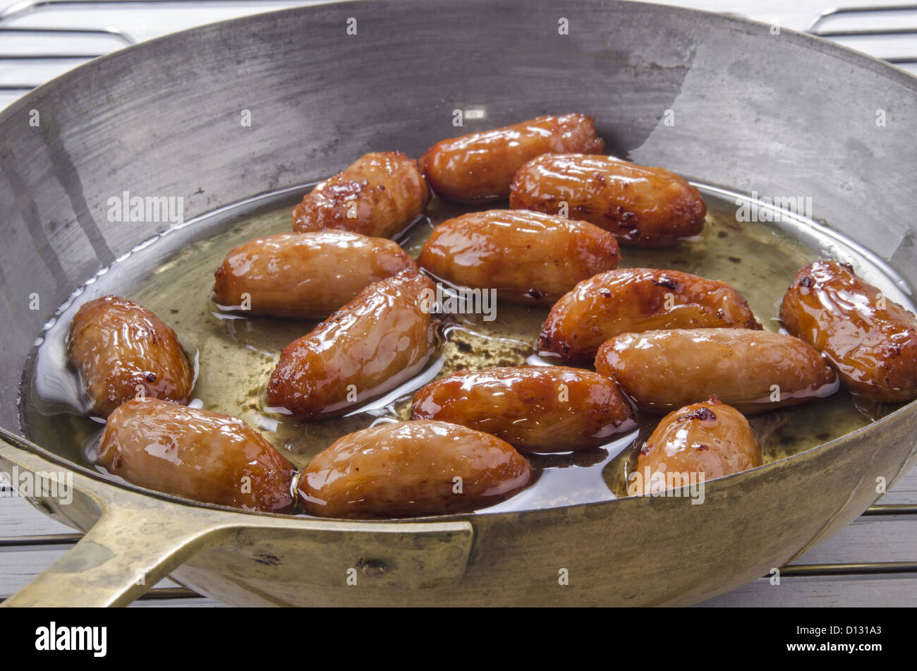 small british sausages in a brass pan Stock Photo