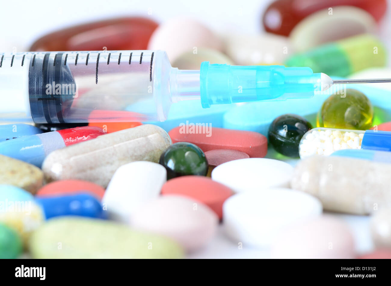 some pills and a syringe isolated on white Stock Photo - Alamy