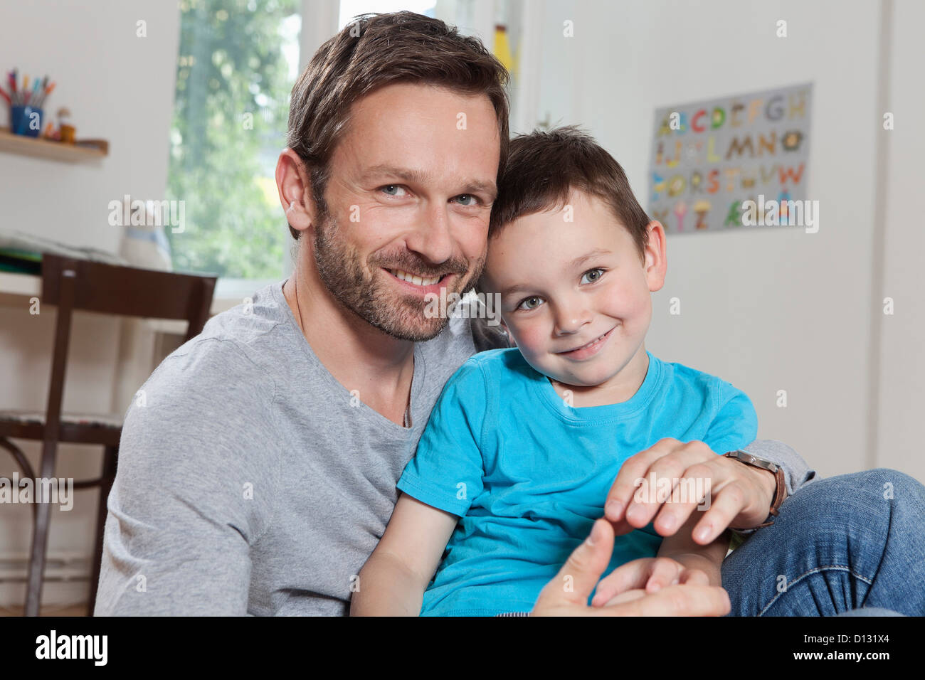 Germany, Berlin, Father and son at home, smiling, portrait Stock Photo ...