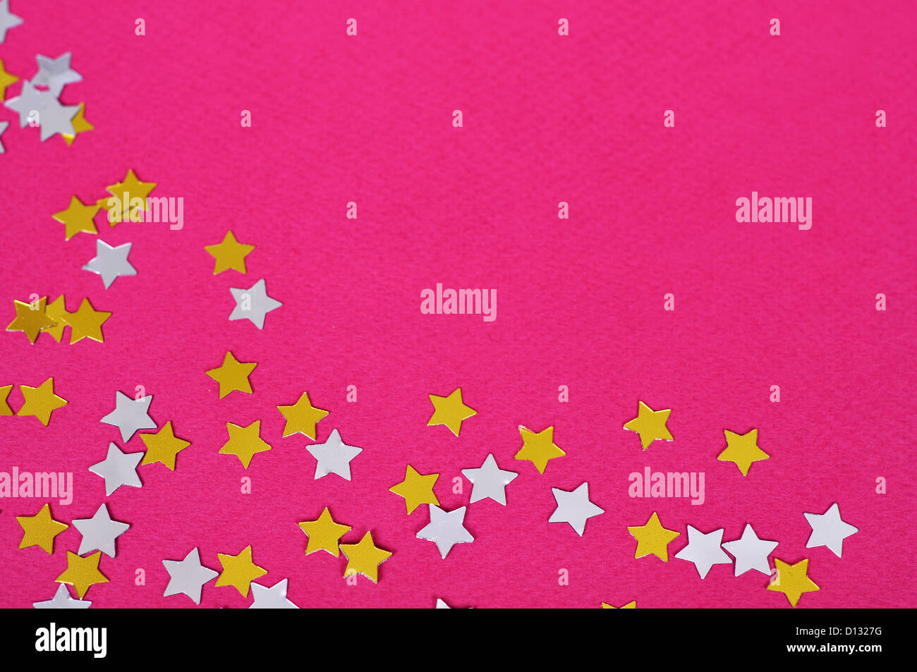 Mix of golden and silver star confetti on pink background Stock Photo ...