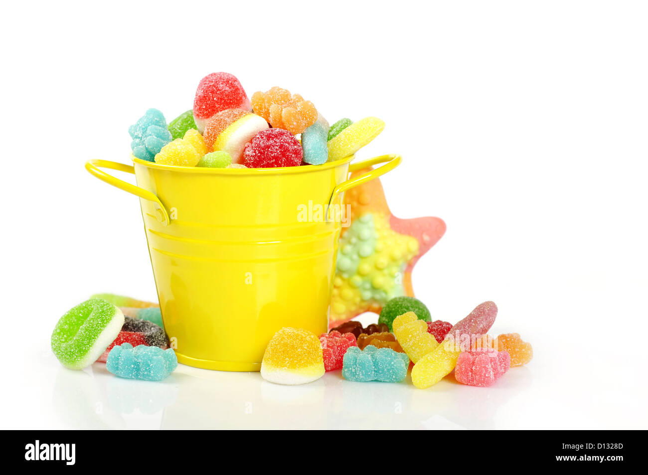 Colorful candies in yellow bucket isolated on white background Stock