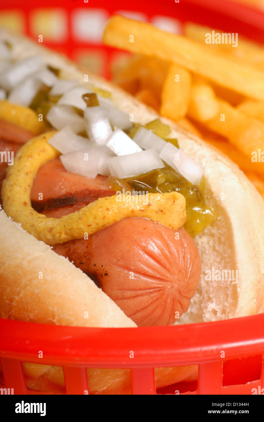 Freshly grilled hot dog and french fries with condiments Stock Photo