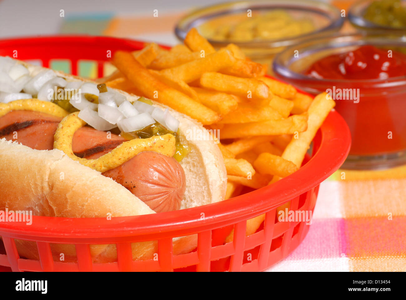 Freshly grilled hot dog with french fries and condiments Stock Photo