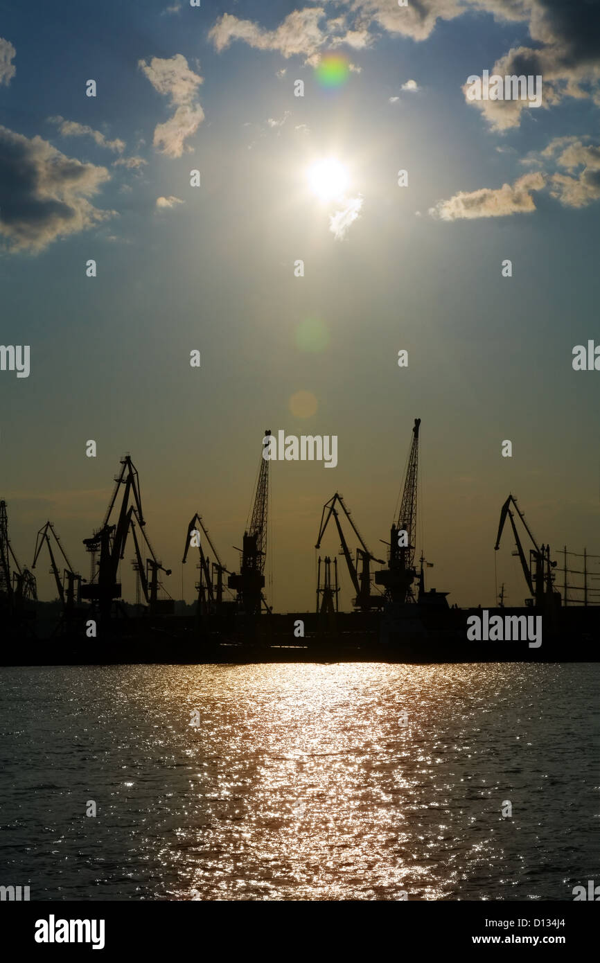 Silhouettes of harbor cranes over blue sky background Stock Photo - Alamy