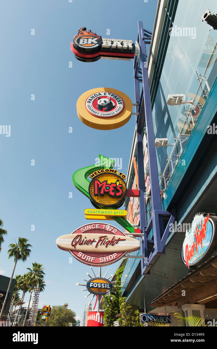 Numerous Colourful Signs Mounted On The Side Of Buildings Against A Blue Sky At Universal Studios; Orlando Florida USA Stock Photo