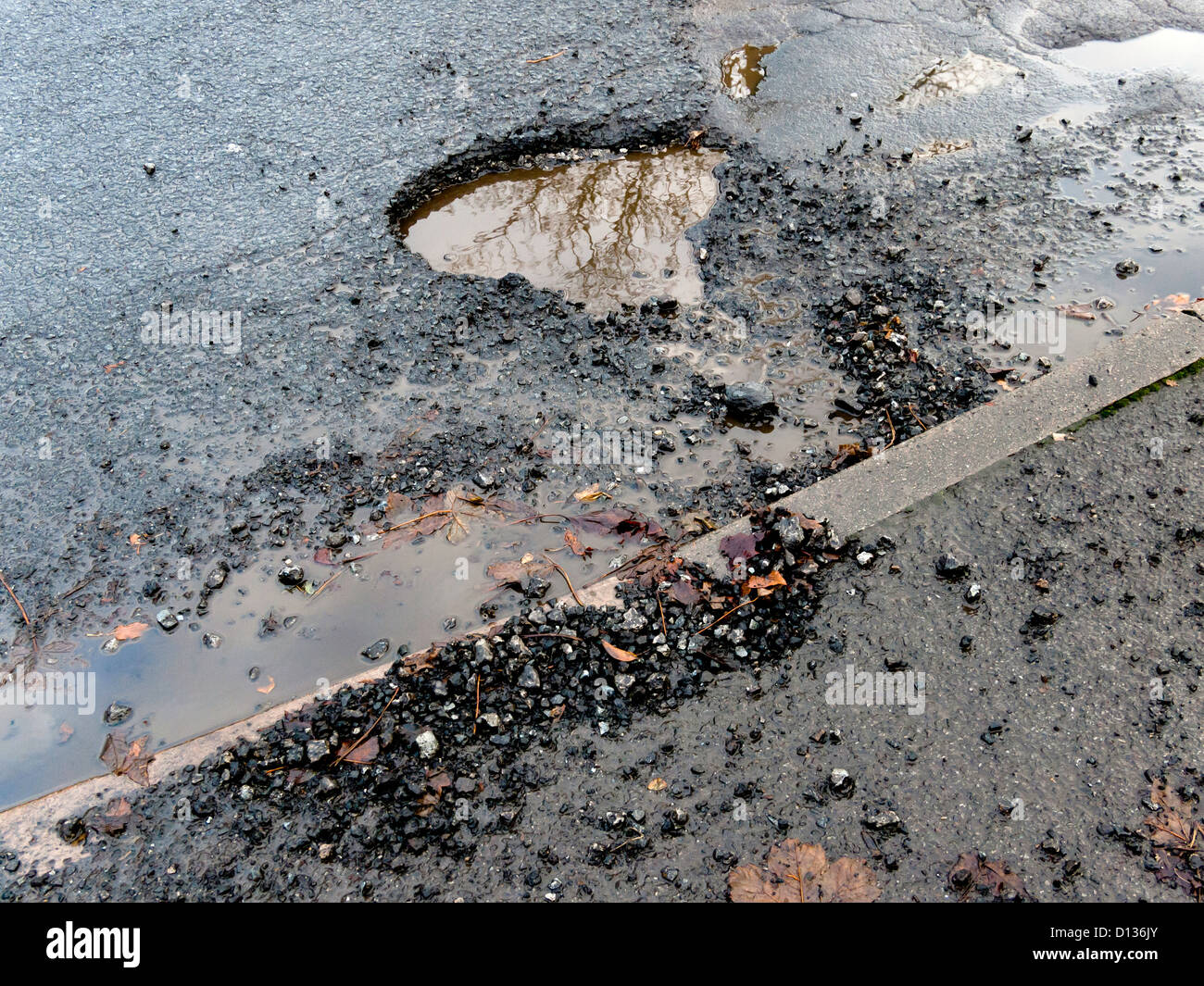 A Pothole Damaged Road Surface Initially Caused By Freezing Weather And a-pothole-damaged-road-surface-initially-caused-by-freezing-weather-and