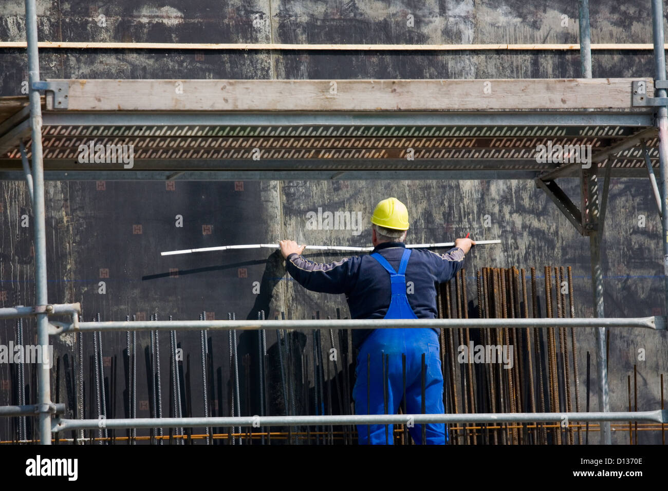Berlin, Germany, builders with ruler on a scaffold Stock Photo - Alamy