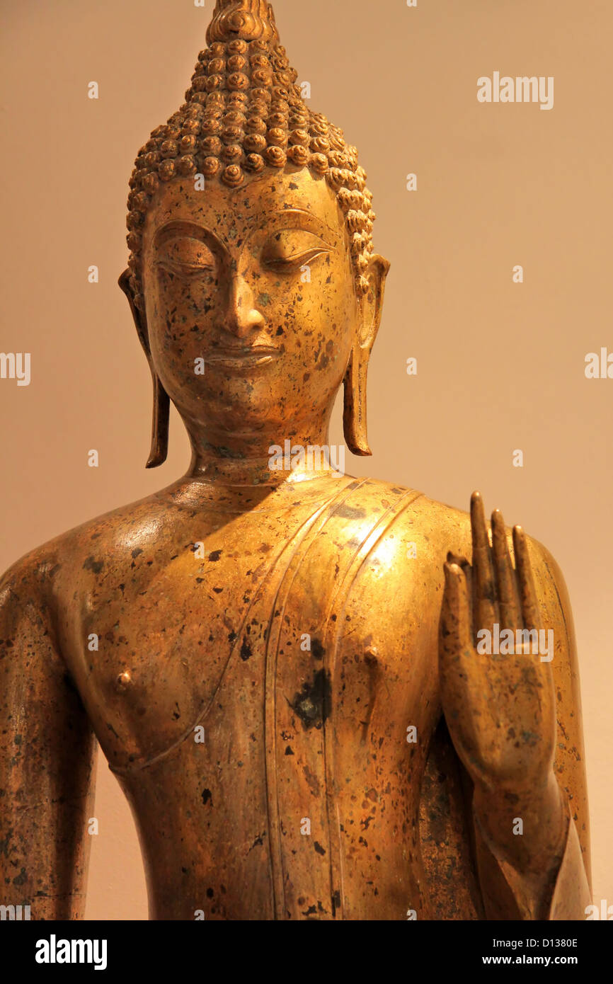 Old historic golden Buddha statue lit atmospherically Stock Photo