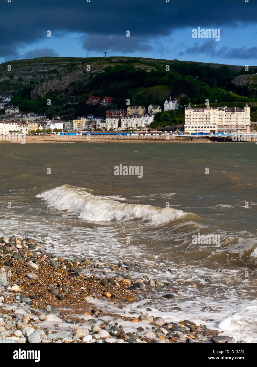 View along the beach at Llandudno in Conwy North Wales UK looking towards the Great Orme with stormy sky above Stock Photo