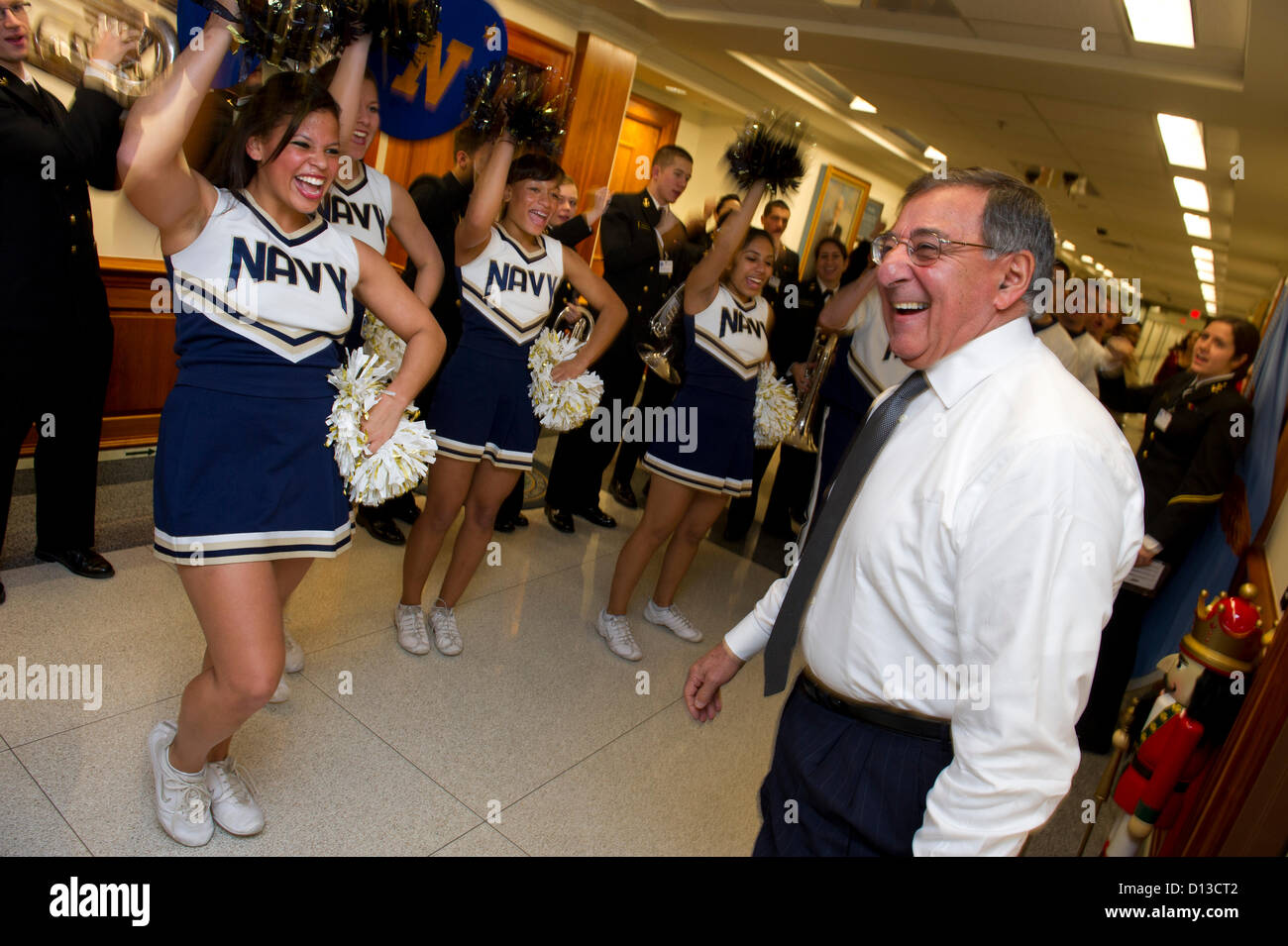 US Secretary of Defense Leon Panetta greets the US Naval Academy Midshipmen cheerleaders and band during a pep rally held in the halls of the Pentagon December 6, 2012. The 113th Army Navy football game will be held this Saturday in Philadelphia. Stock Photo