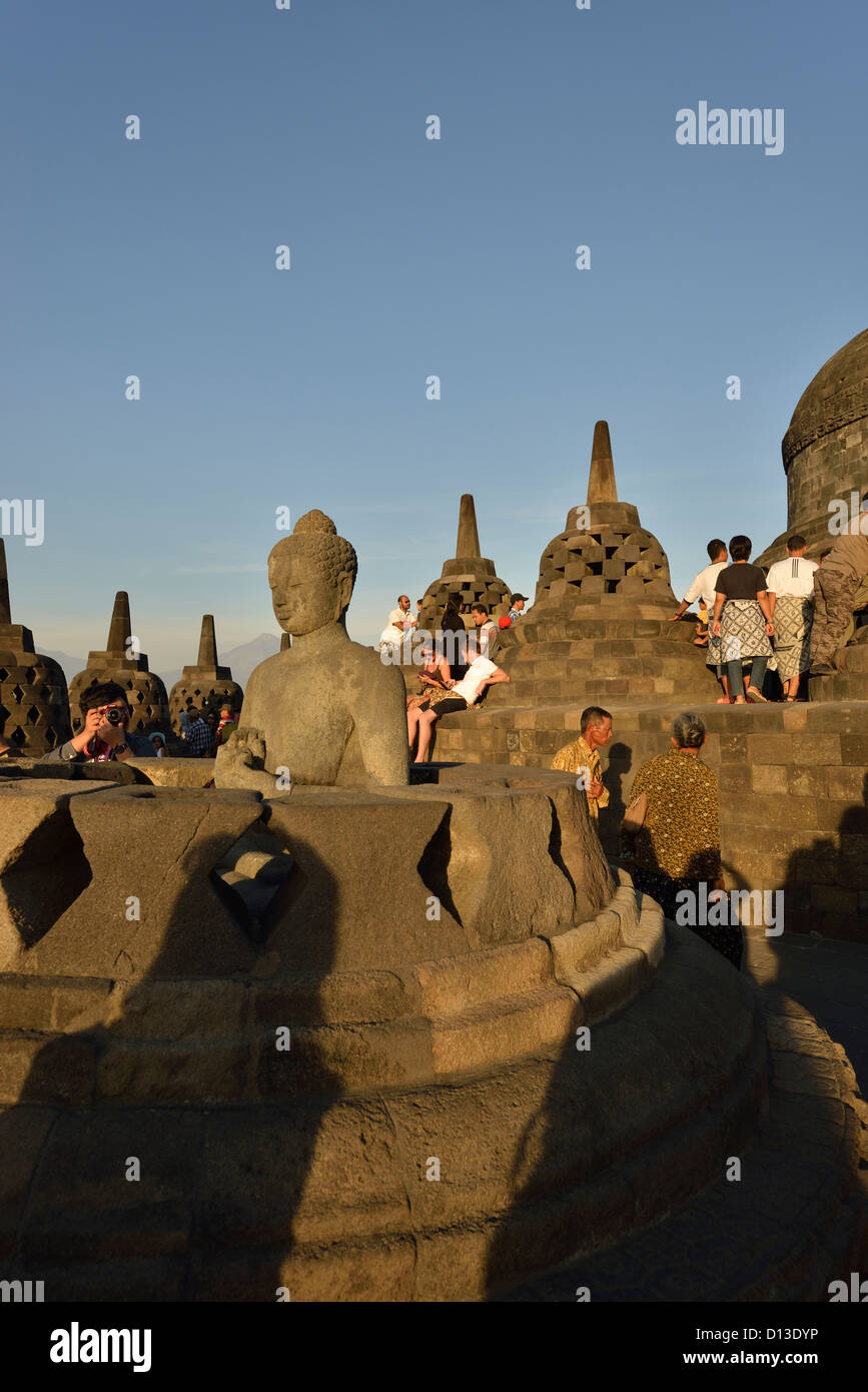 Tourists roam around the ethereal Buddha at the top of the stunning Borobudur; Central Java, Indonesia. Stock Photo