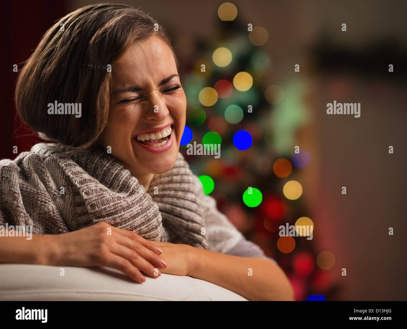 Laughing young woman in front of Christmas tree Stock Photo