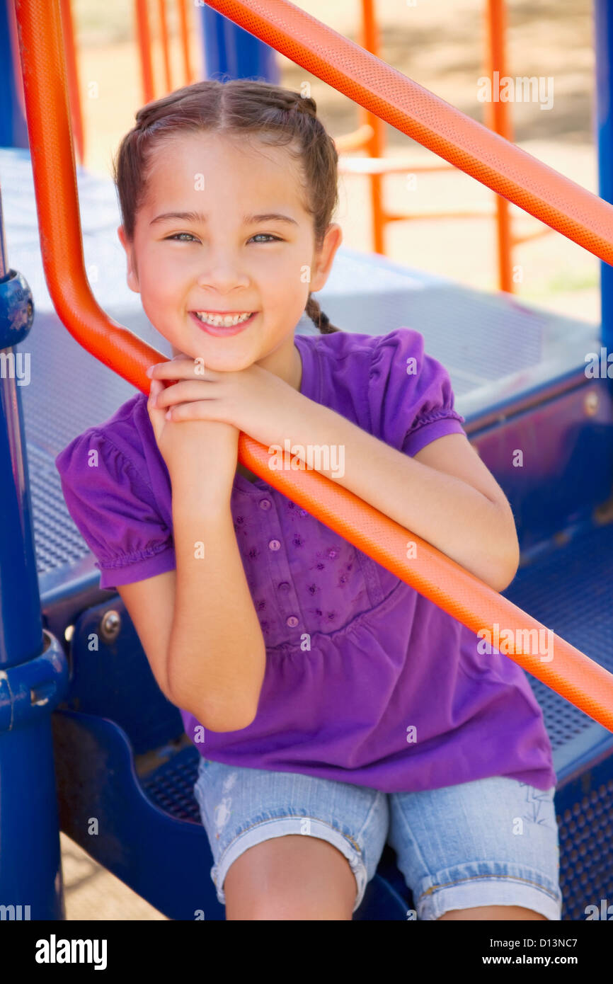 Hawaii, Young Girl Sitting On Jungle Gym Steps In The Park Stock Photo