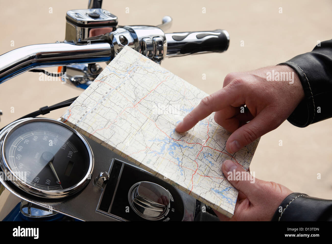 USA, Illinois, Metamora, Close up of man's hand holding map near motorcycle handlebars Stock Photo