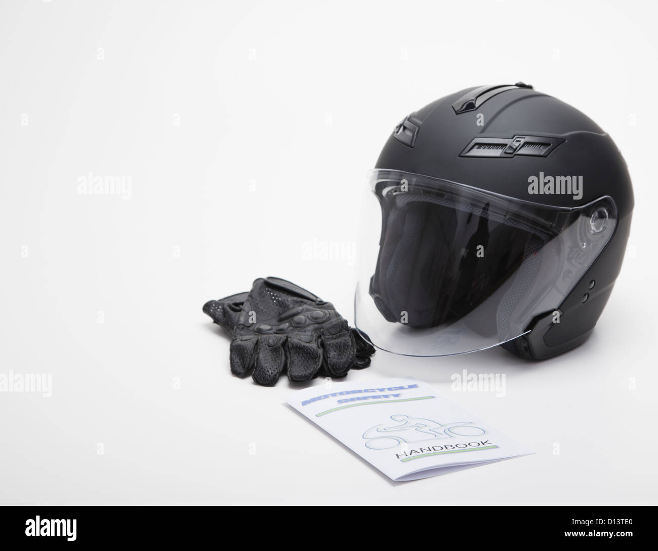 Close up of motorcycle helmet,  leather gloves and safety guideline book, studios shot Stock Photo