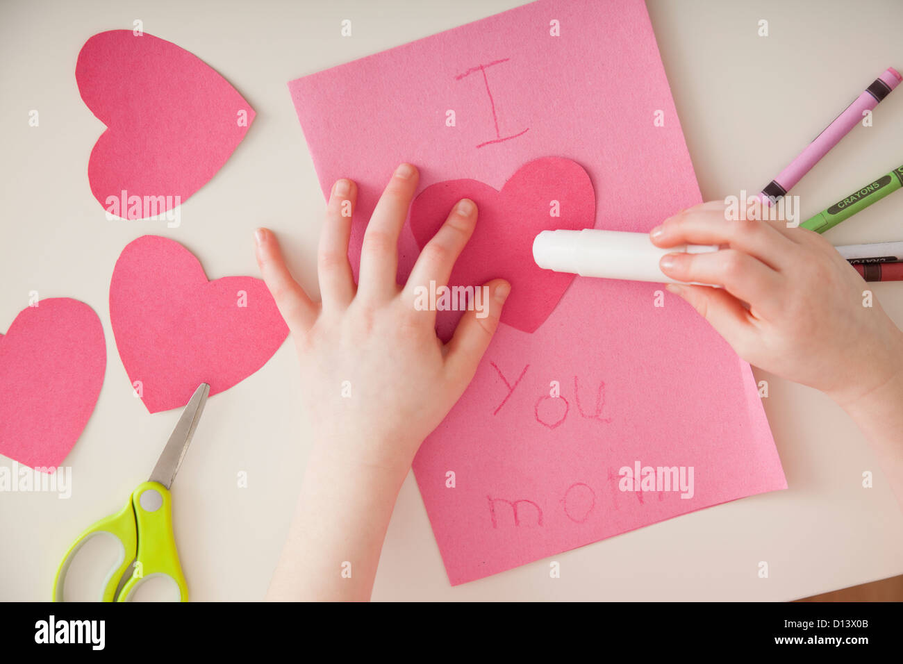 USA, Illinois, Metamora, Close up of girl's (4-5) hands preparing greeting card for Mother's Day Stock Photo