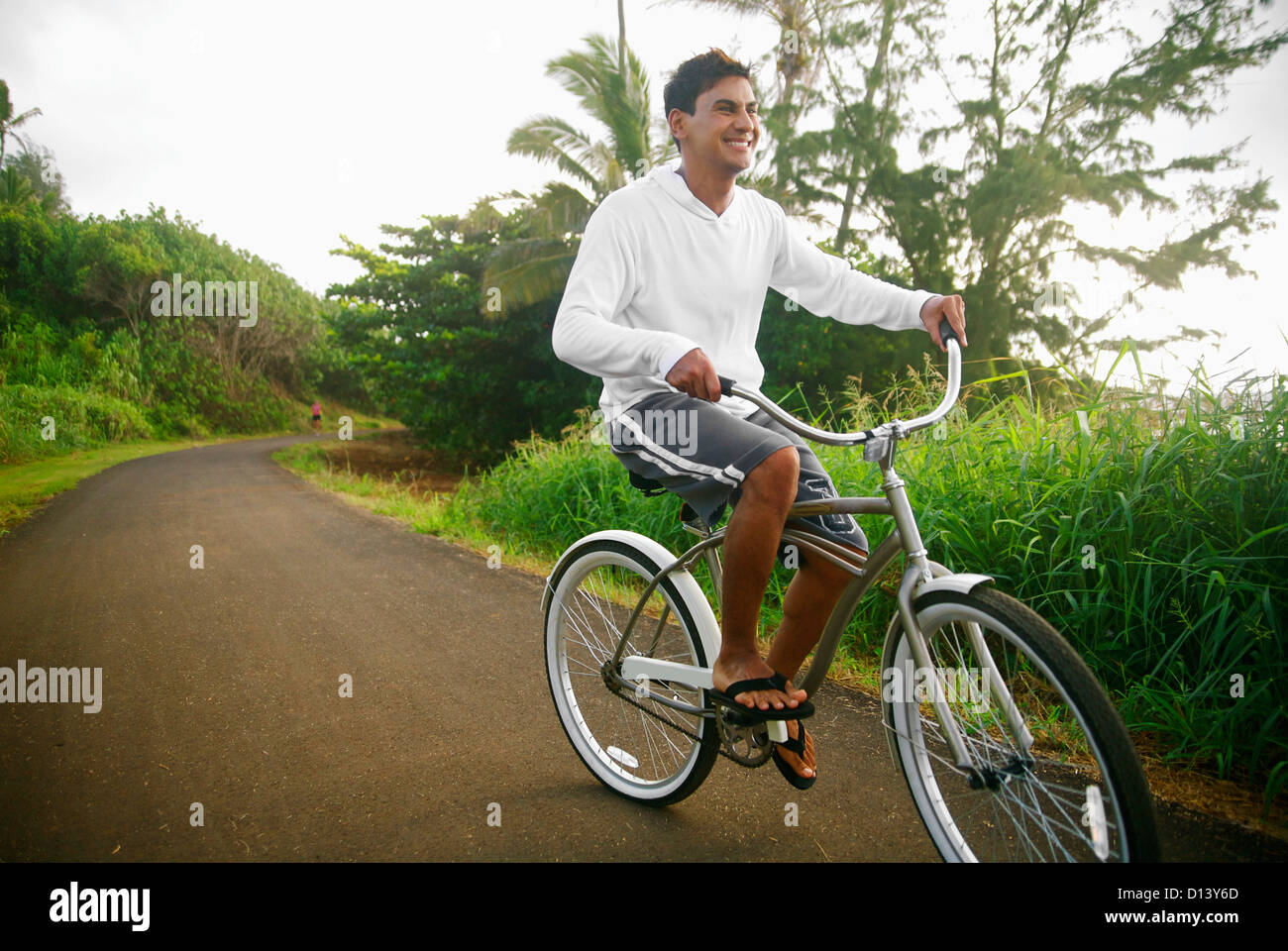 Hawaii, Kauai, Kealia Beach, Young Man Riding A Bike On The Bike Path