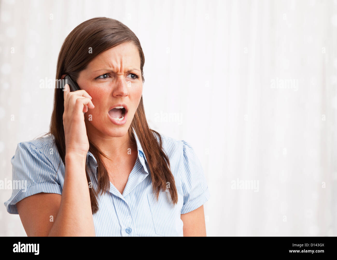 USA, Illinois, Metamora, young woman shouting into mobile phone Stock Photo