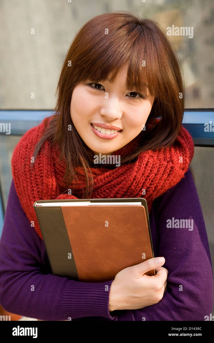 Asian college student girl holding book. Stock Photo