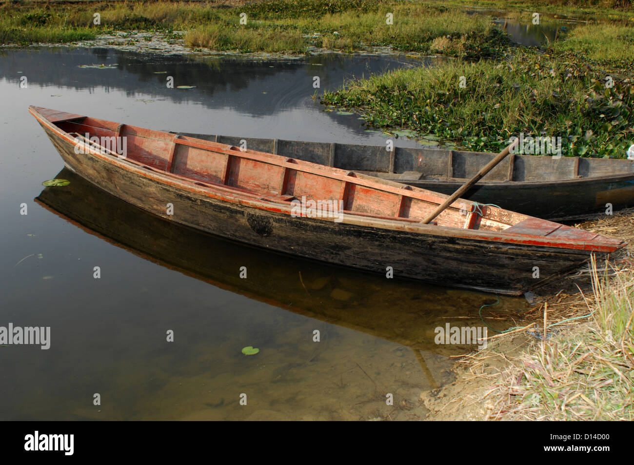 a wooden boat sits on the edge of a tranquil lake Stock Photo - Alamy