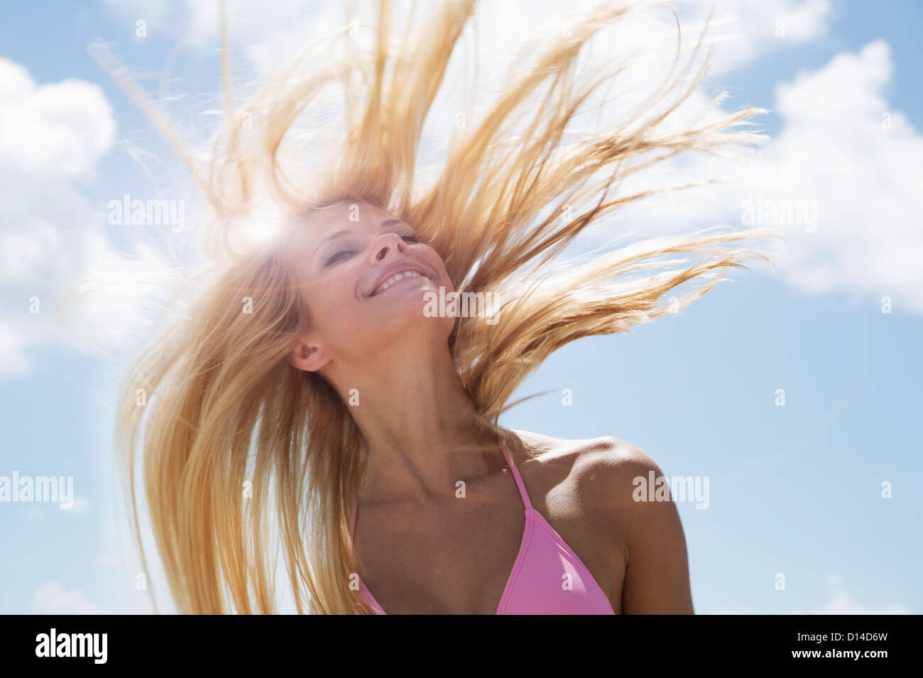 Smiling woman tossing her hair Stock Photo