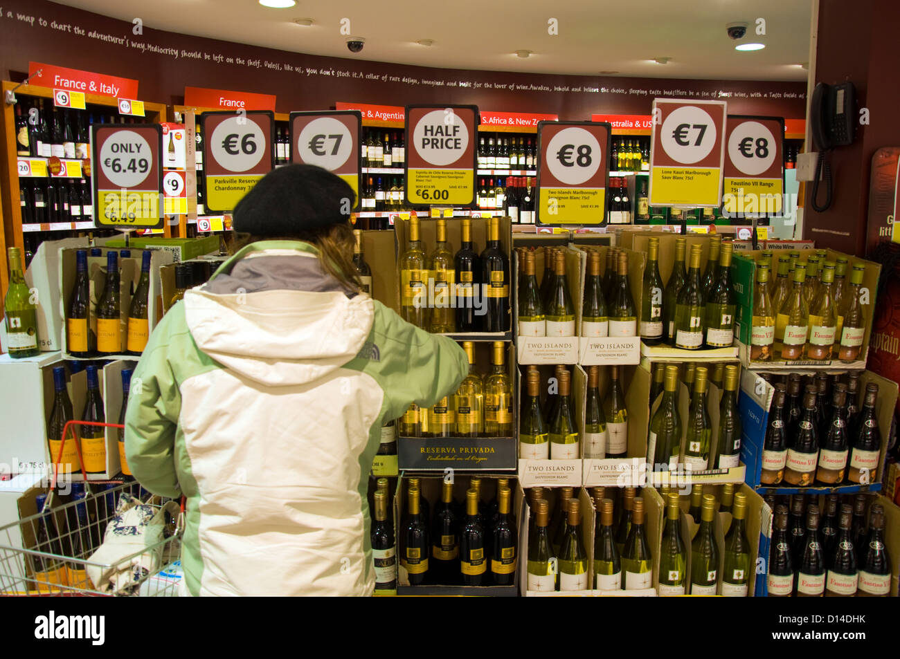 A woman in a supermarket Supavalue buying wine Stock Photo
