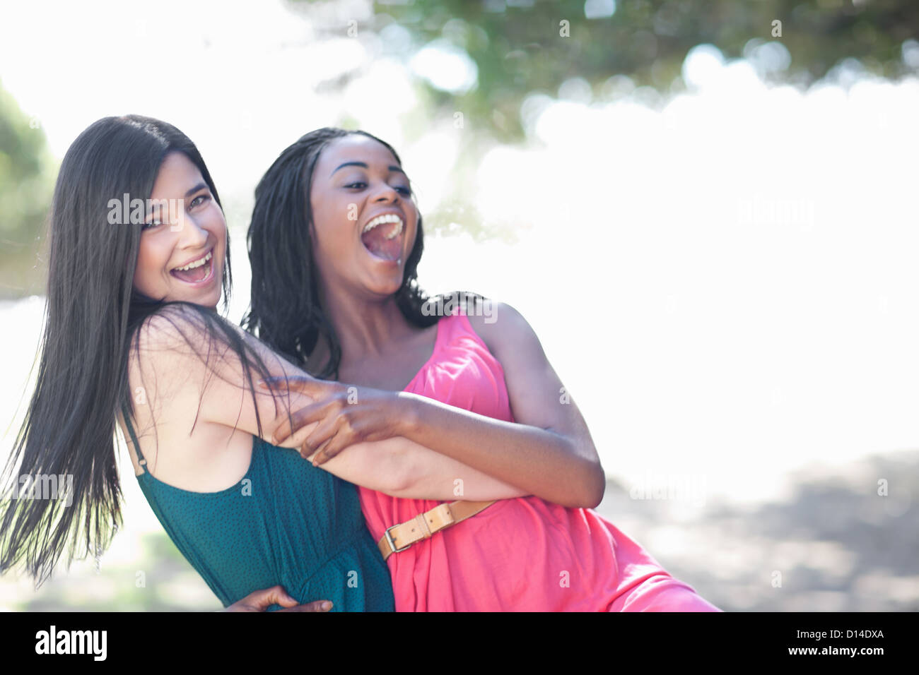 Smiling women hugging outdoors Stock Photo - Alamy