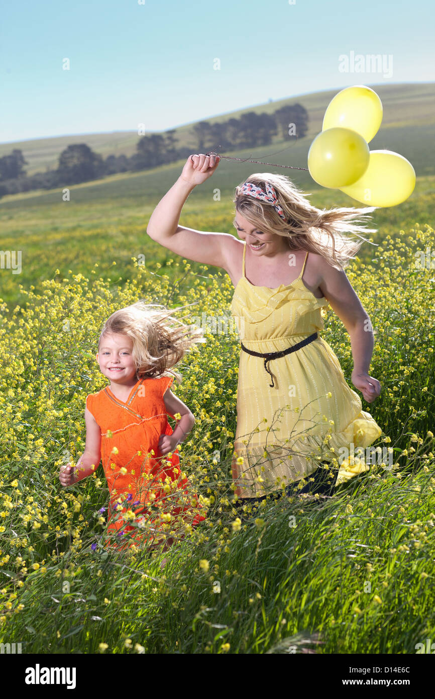 Sisters playing in field of flowers Stock Photo