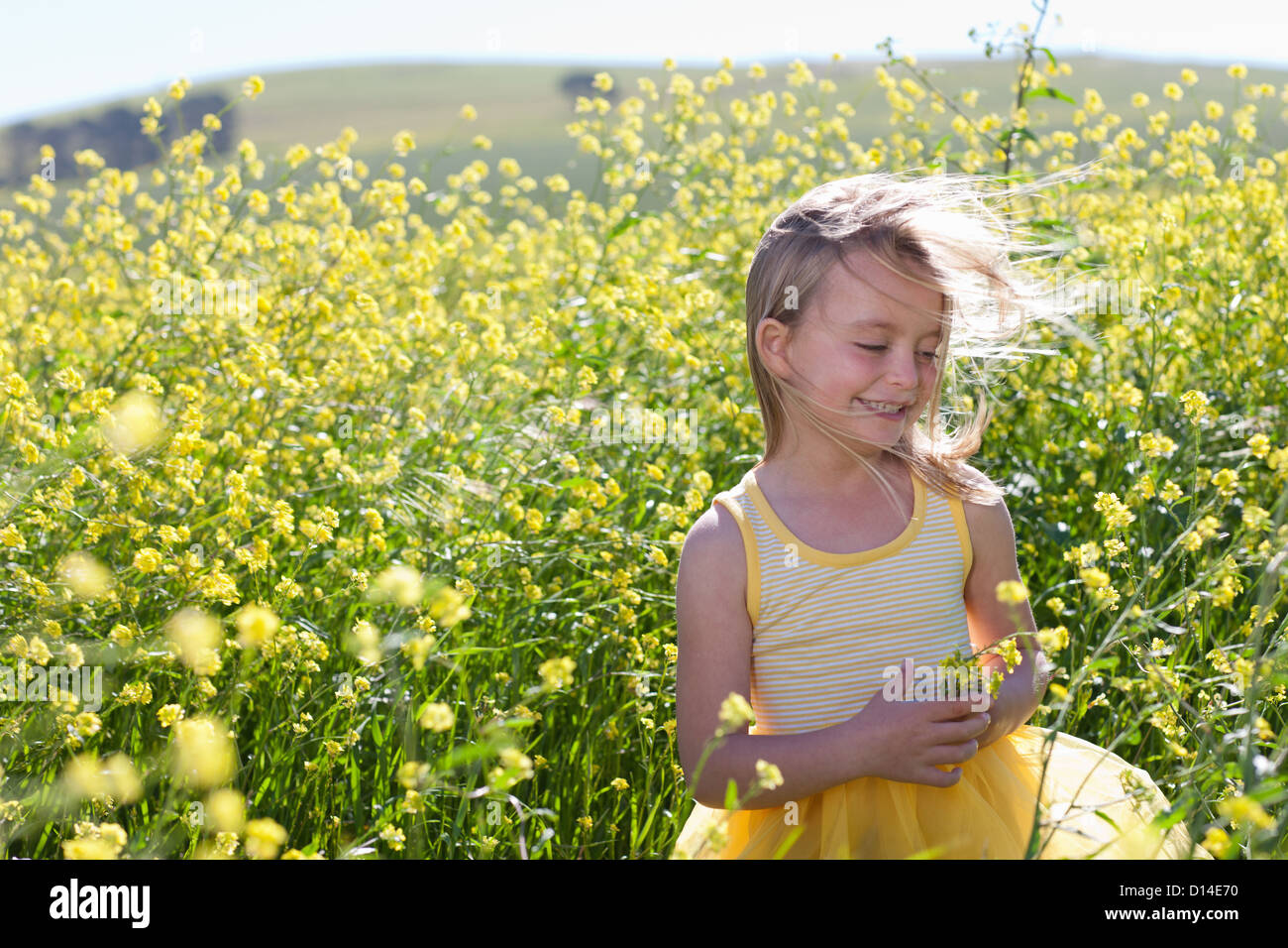 Smiling girl playing in field of flowers Stock Photo - Alamy