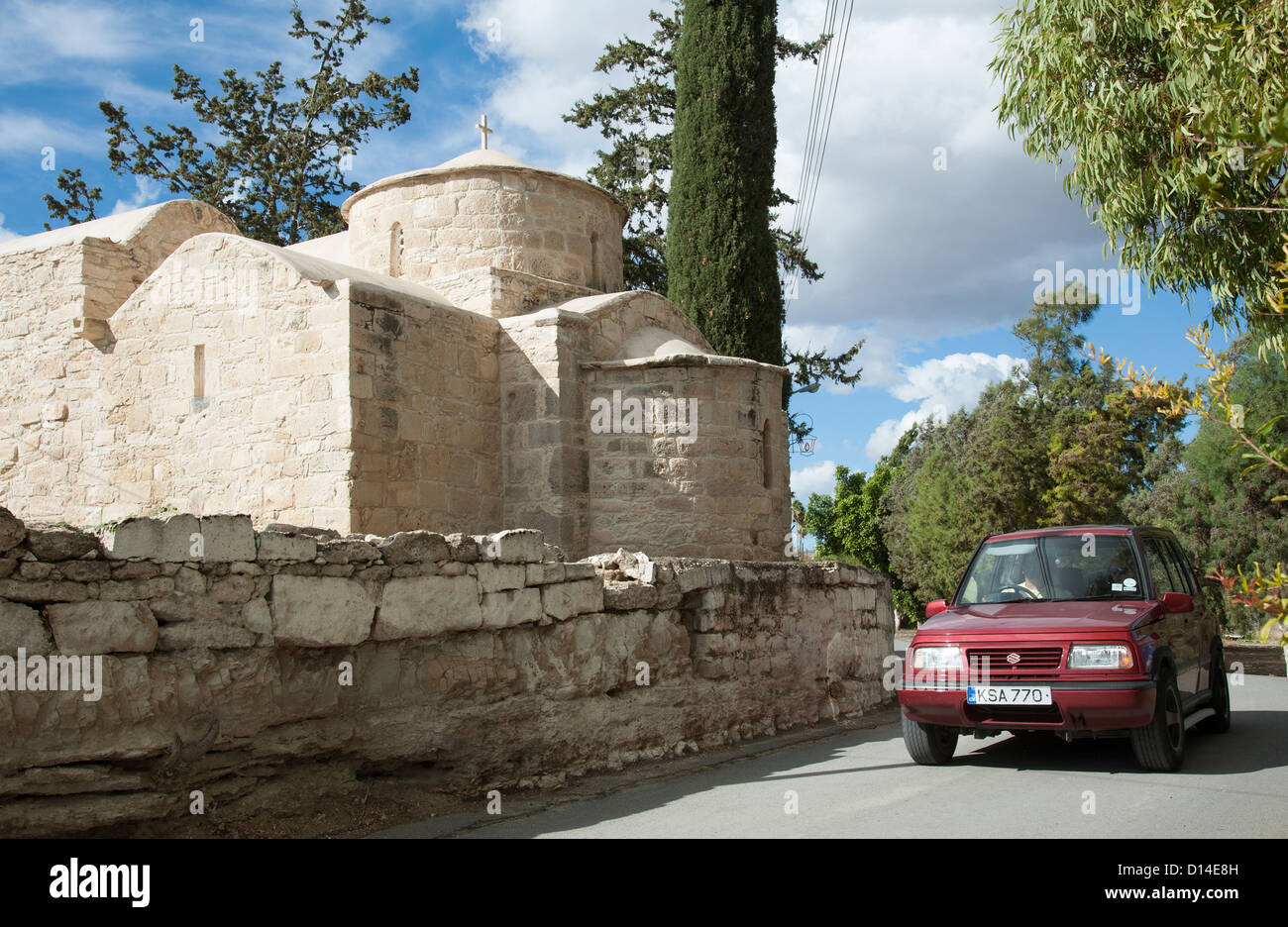 Car passing old church in Kolossi village west of Lemesos Cyprus Stock Photo