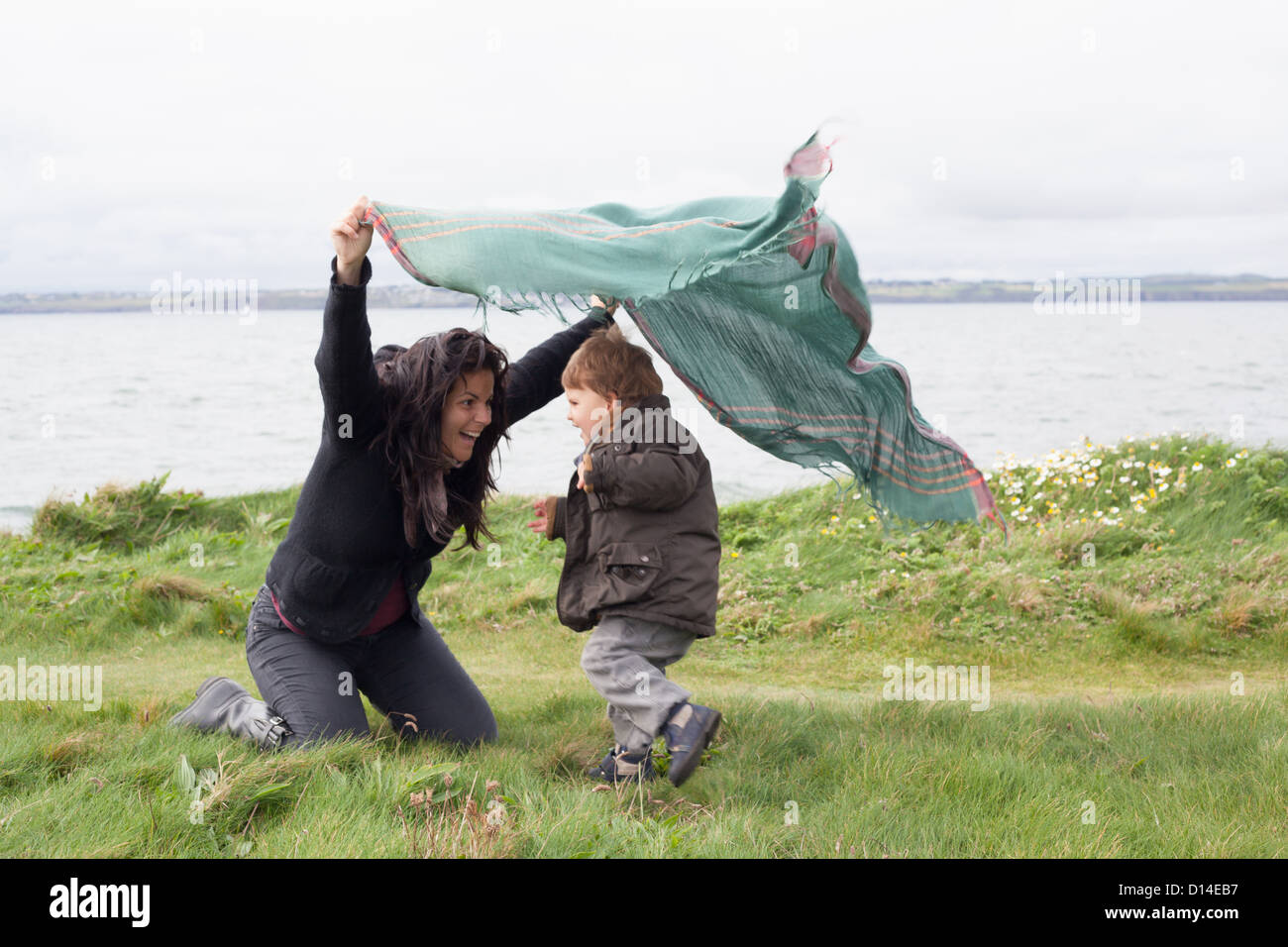 Mother and son playing in grassy field Stock Photo